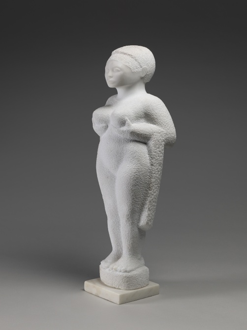 A white stone sculpture of a figure standing with hands cupping the underside of breasts and stippled texture.